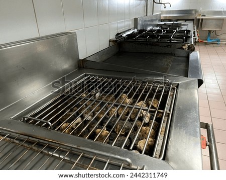 Lava rock grills in hotel kitchens are used for grilling food such as steaks, which distributes heat evenly throughout the grill, helping to control the degree of doneness in the meat. and save gas. Royalty-Free Stock Photo #2442311749