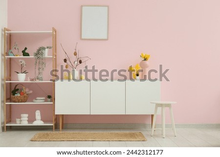 White chest of drawers and shelving unit with Easter decor in stylish living room