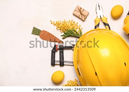 Composition with construction tools and Easter decor on light background