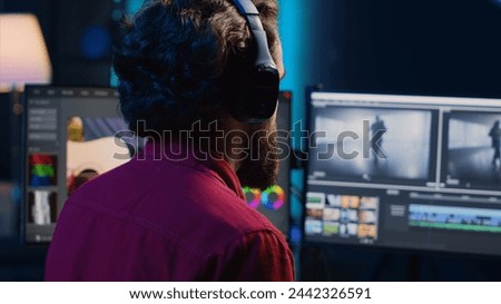 Video editor analyzing film montage before editing color balance and lighting in creative office. Post production studio employee working with raw footage while listening music in headphones