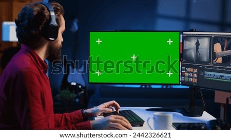 Videographer using professional software on chroma key PC to create visual effects for video projects. Expert using post production techniques to edit raw clips footage on isolated screen monitor