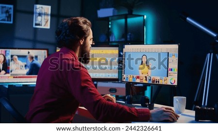 Photo editor color correcting photographs in creative studio using graphic tablet, jib down shot. Photographer selecting best pictures for editorial content using stylus on touchscreen device