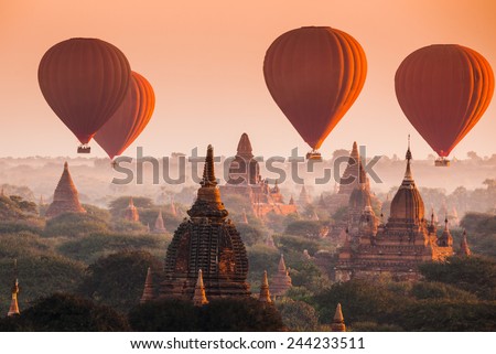 Hot air balloon over plain of Bagan in misty morning, Myanmar Royalty-Free Stock Photo #244233511