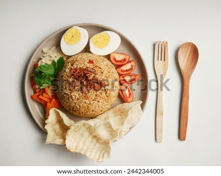 flat lay fried rice with boiled egg, vegetable salad, tomatoes and crackers. with a white background