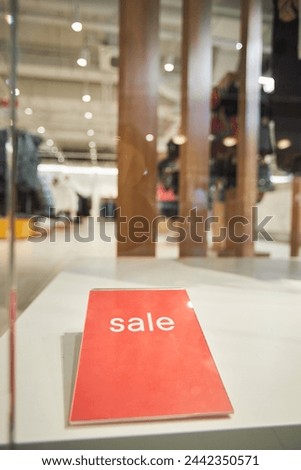 Close up background image of red Sale sign in window display of shopping mall copy space