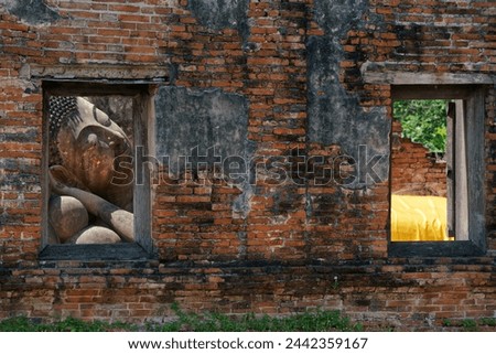 reclining buddha statue in the ancient temple looking through the window wall