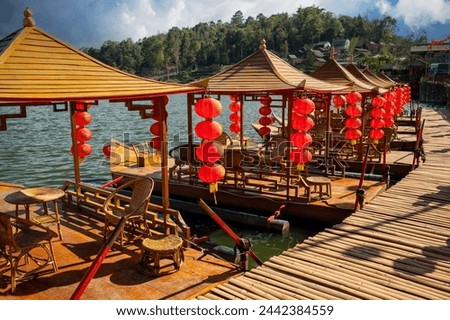 Beautiful views of hills, Chinese buildings and ancient boats in the lake serve tourists at Baan Rak Thai Chinese characters on red lanterns- translated text means port, happiness, good luck,wealth