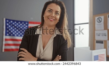 Confident woman crossing arms in front of us flag at indoor electoral office