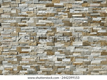 Large stone coating wall made of  bricks and cubes of  multicolor rocks. Panels for exterior, background and texture.