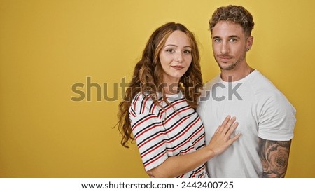 A loving couple embracing against a vibrant yellow background, displaying affection and happiness in their relationship.