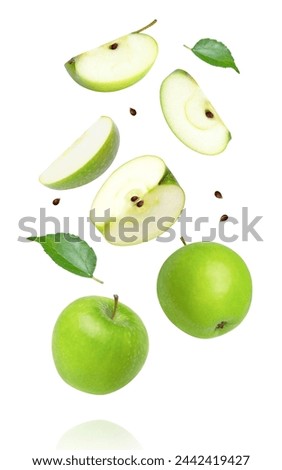Green apple and cut in half sliced with leaves flying in the air isolated on white background.  Royalty-Free Stock Photo #2442419427