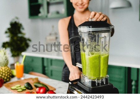 Close up photo of a girl making detox cocktail using blender in the kitchen. Smoothie and super food for healthy diet and eating habits. Vitamins and fiber source