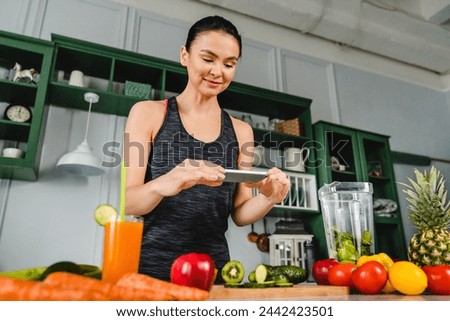 Young caucasian woman blogger taking photo of the organic vegan food in the kitchen. Healthy food vlog about veganism and vegetarianism, calories losing weight