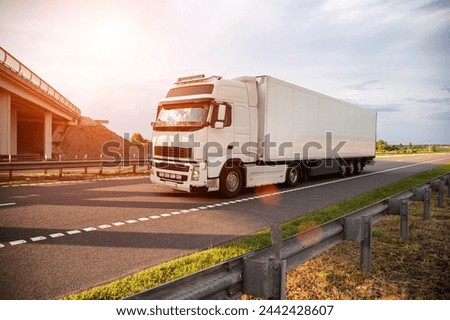 A white modern truck with an isothermal refrigerated semi-trailer transports perishable products in a trailer with a constant temperature regime. Transportation of seafood, fruits and meat. Royalty-Free Stock Photo #2442428607