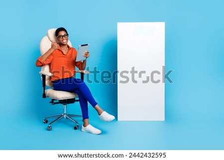Photo of lady sit chair hold e-book raise thumb up empty space poster wear specs brown shirt isolated blue color background