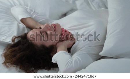 Young woman sleeping in bed. Portrait of a beautiful woman resting on a comfortable bed with pillows in white bedding in the bedroom in the morning. High quality image.