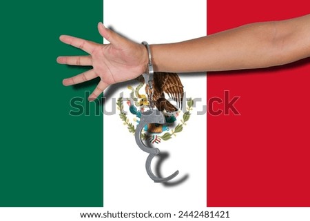 handcuffs with hand on Mexico flag