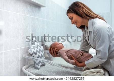 Doctor pediatrician examining new born baby boy in clinic. Nurse dressing infant baby girl. Medical checkup. Health care concept. A female nurse of is holding a newborn baby at the hospital. 