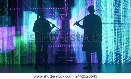 People against big digital wall in studio. Man and woman with japanese swords katanas stand in front of digital screen neon graphic visual background.