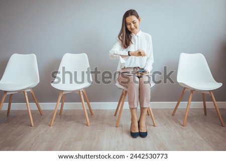Businesswoman waiting for job interview. Stressful young woman waiting for job interview. Studio shot of a young businesswoman using a laptop while waiting in line against a gray background