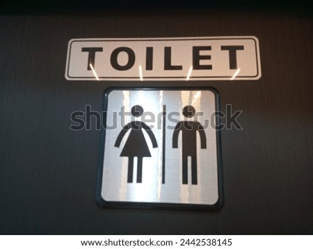 sign of separate women's and men's toilets with black doors