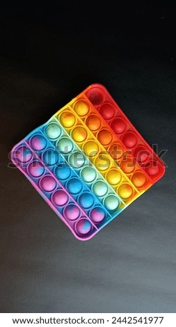 Closeup colorful poppit it game on black background Royalty-Free Stock Photo #2442541977