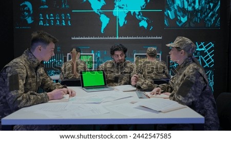 Group of security squad in control center. Military headquarters surveillance officers working in office on laptop with chroma key green screen. Royalty-Free Stock Photo #2442547585