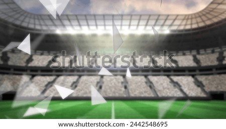 Image of failing shapes and glowing lights over football stadium. World cup soccer concept digitally generated image.