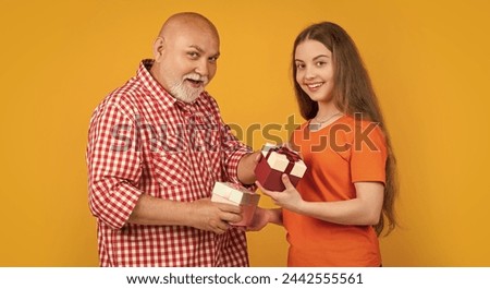 smiling child and grandfather with present box for anniversary