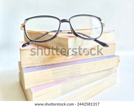 glasses that are in a pile of books isolated on white background.