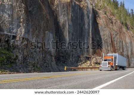 Industrial carrier long hauler big rig semi truck tractor with extended cab for truck driver rest transporting cargo in dry van semi trailer driving on the winding mountain road in Columbia Gorge Royalty-Free Stock Photo #2442620097
