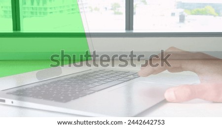 Image of hands using laptop with green screen over sped up commuters walking in modern building. business and communication technology concept digitally generated image.