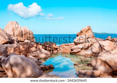 natural rock pool in picturesque heart shaped cloud in the bright blue sky, epic view picturesque bright nature in Seychelles La Digue, lake and granite stones
