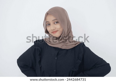 Beautiful smiling Asian woman in a black dress and hijab looking at the camera with confident isolated on white background