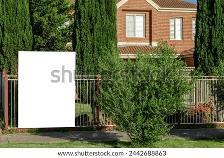 Real Estate Billboard Mockup Outside a Suburban Australian House: An empty, blank white background provides texture for advertising. ample copy space for your 'House for Sale' or 'For Rent' designs.