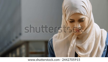 Image of smiling asian woman in hijab with smartphone over cityscape. out and about in the city, digitally generated image.