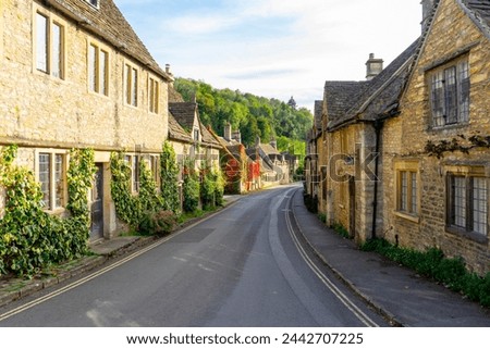 Scenic view of traditional old cottage houses and a street by a river in a beautiful English village, Castle Combe village in the Cotswolds Area of Outstanding Natural Beauty in Wiltshire, England. Royalty-Free Stock Photo #2442707225