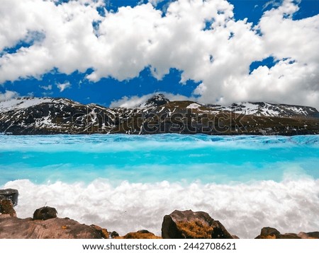 Blue water and blue sky with white clouds 