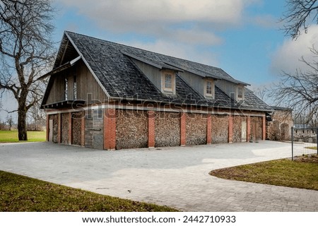 An old barn or shed was used to make a summer house with walls made of firewood. Construction materials- timber, logs, wood, brick. Location in Zemgale, Latvia, Europe. Well kept