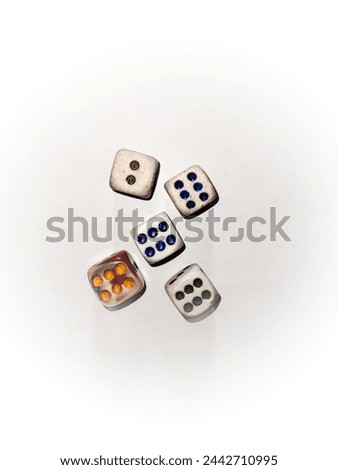 this image features five colorful dice mid-roll against a white backdrop, symbolizing the unpredictability of games of luck. Six in dice