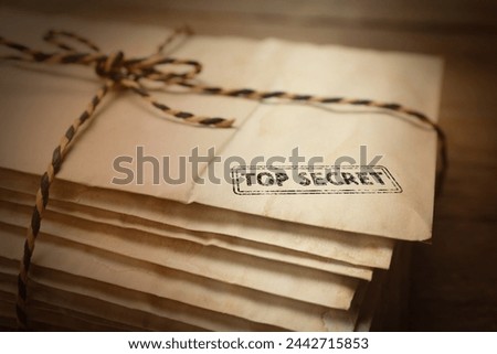 Top Secret stamp. Stacked old letters tied with string on table, closeup