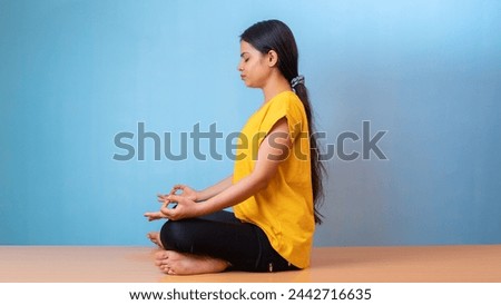Beautiful woman practicing Siddhasana, also known as Accomplished pose or Perfect pose yoga, isolated indoor home background