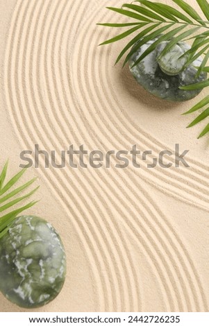 Zen concept. Stones, leaves and pattern on beige sand, flat lay. Space for text