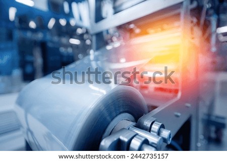 Operation of automatic machine plastic form for kit medical production. Closeup of roller blue toning, with sun lighting effect. Royalty-Free Stock Photo #2442735157