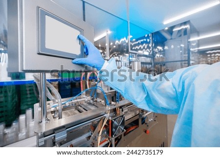 Worker control production line automatic machine for manufacture of medical plastic form for surgical kit on medicine factory Royalty-Free Stock Photo #2442735179