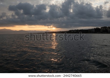 Sunrise on the seaside with clouds and sun in horizont.