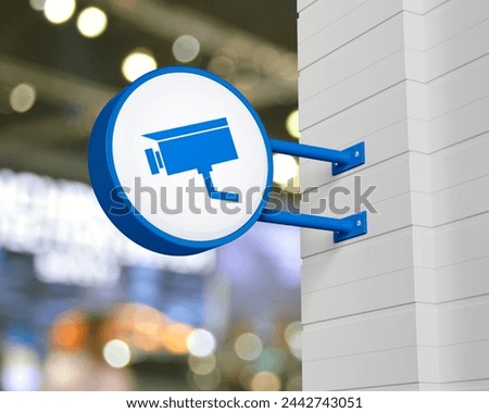 Cctv camera icon on hanging blue rounded signboard over blur light and shadow of shopping mall, Technology security and safety online concept, 3D rendering