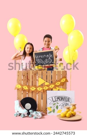 Cute little children with chalkboard and lemons at lemonade stand on pink background