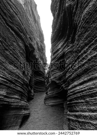Stark and dramatic beauty of the volcanic crevice in Lanzarote. The jagged edges of the crevice are clearly visible, and the contrast between the black and white tones creates a sense of depth. Royalty-Free Stock Photo #2442752769