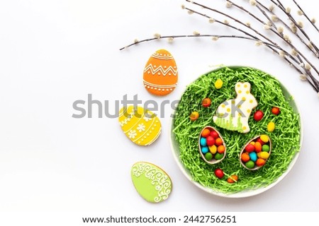 Easter eggs and bunny cookies with spring willow branch. Festive baking cooking flat lay.